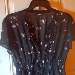 Sheer black blouse with hummingbird pattern.